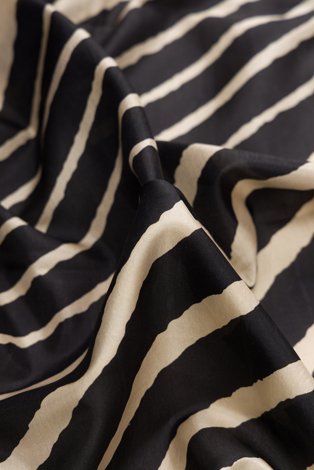 Close up of Black Dual Tone Printed Silk Saree with Printed design on the body and Printed Border.  displaying folds