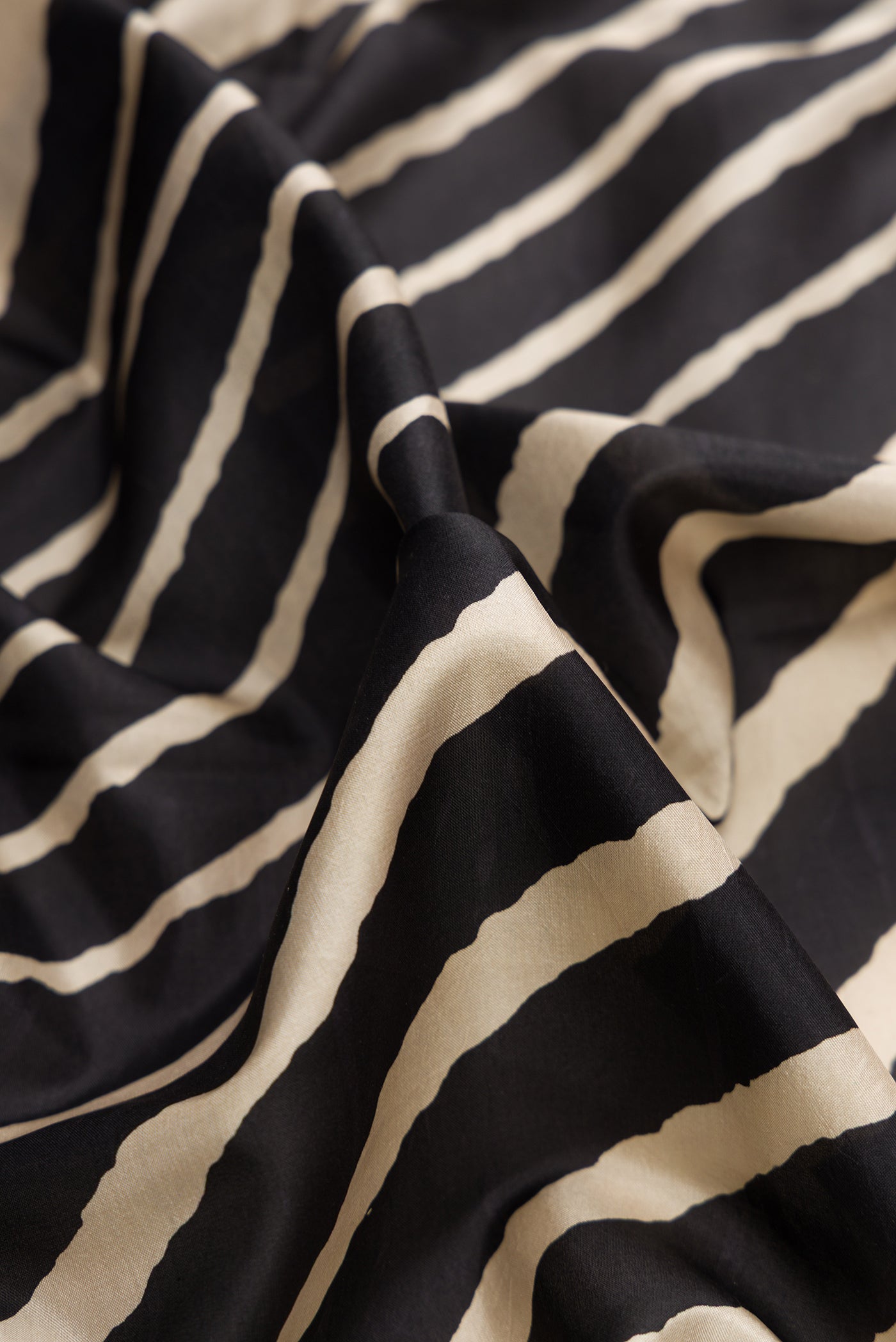 Close up of Black Dual Tone Printed Silk Saree with Printed design on the body and Printed Border.  displaying folds