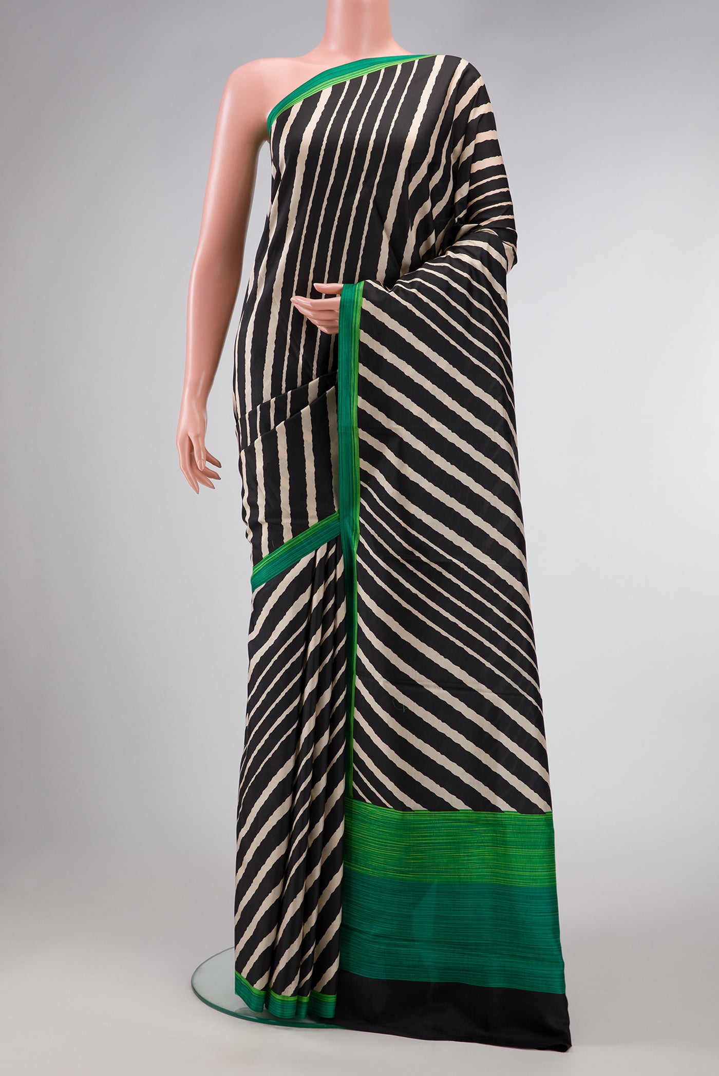 Black Dual Tone Printed Silk Saree with Printed design on the body and Printed Border.  displayed on a mannequin
