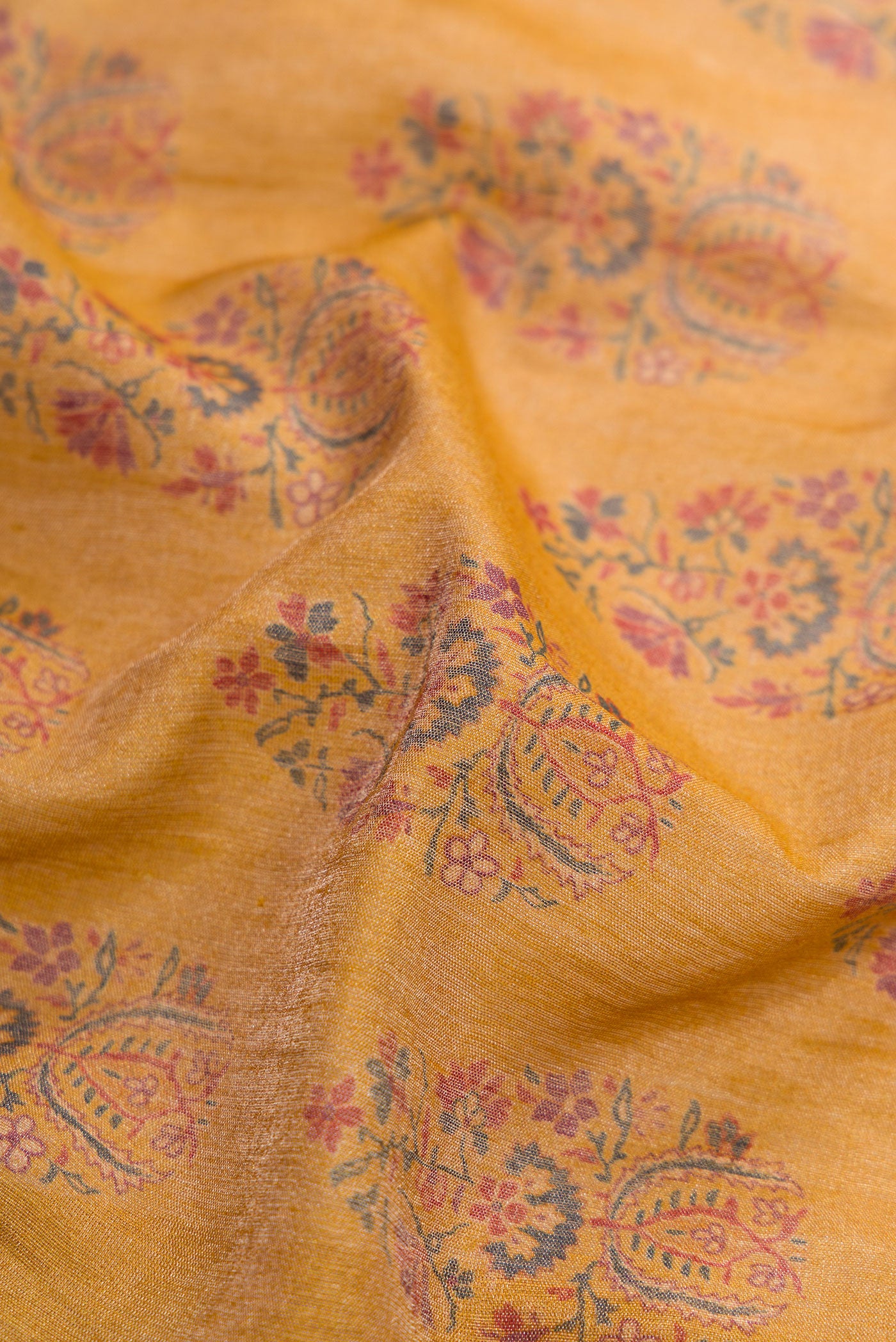 Close up of Mustard Dual Tone Tussar Silk Saree with Printed design on the body and Zari Border.  displaying folds