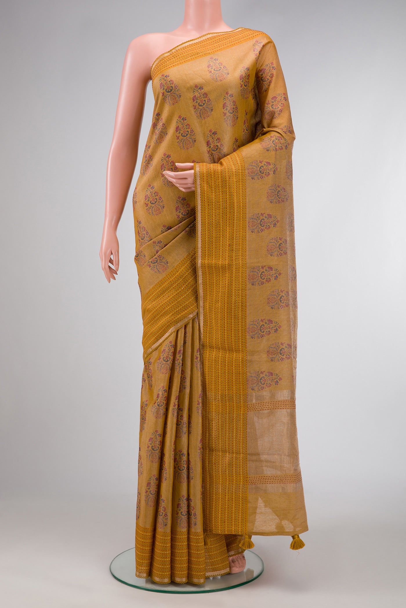 Mustard Dual Tone Tussar Silk Saree with Printed design on the body and Zari Border.  displayed on a mannequin