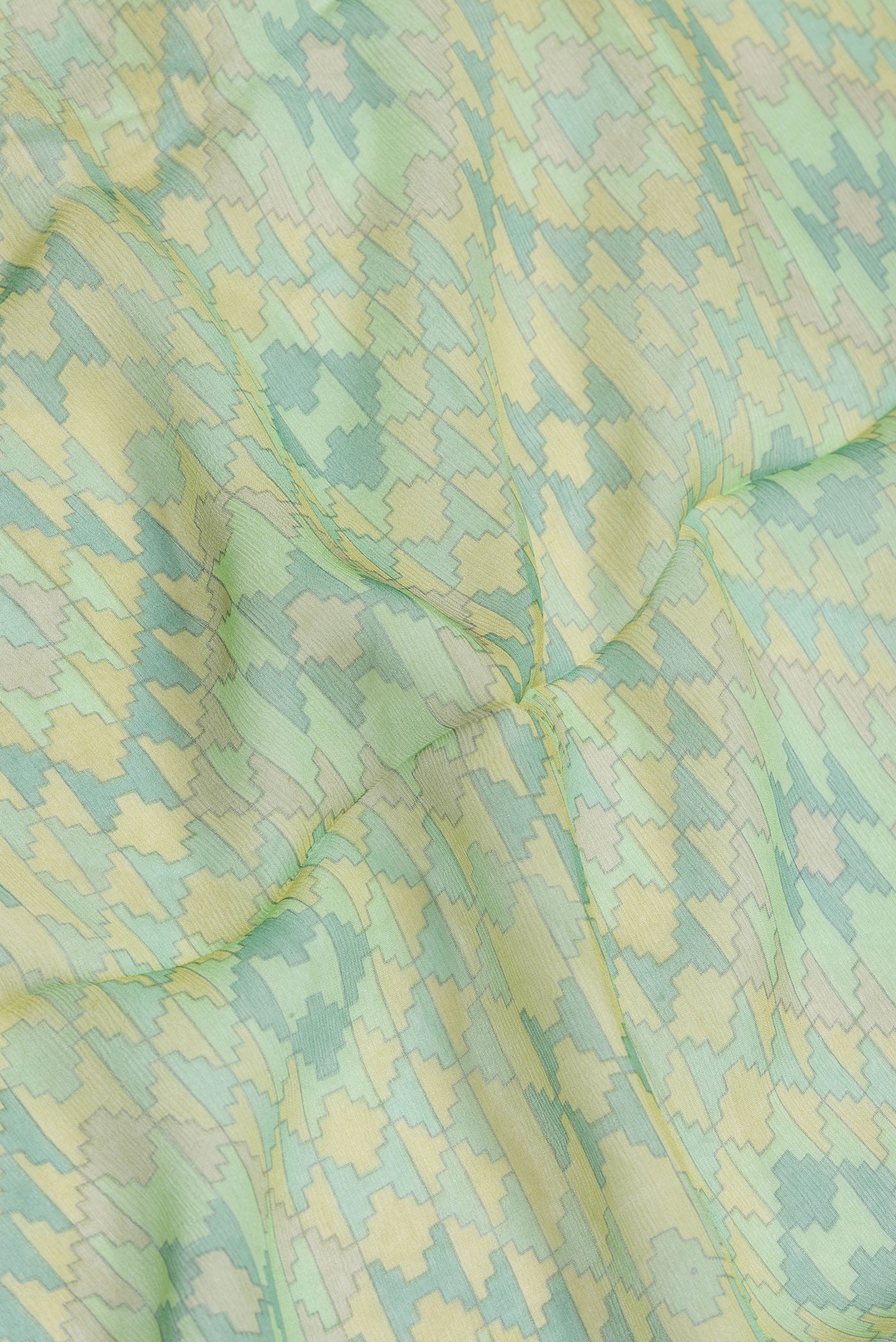 Close up of Green Dual Tone Mysore Chiffon Saree with Printed design on the body and Zari Border.  displaying folds