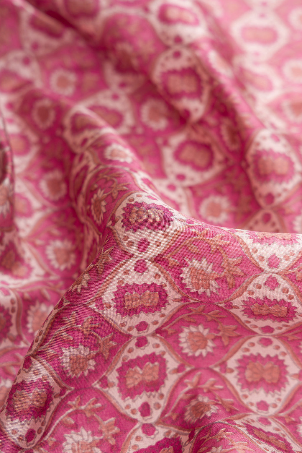 Close up of Dark Pink Dual Tone Kanchipuram Silk Saree with Printed design on the body and Zari And Thread Border.  displaying folds