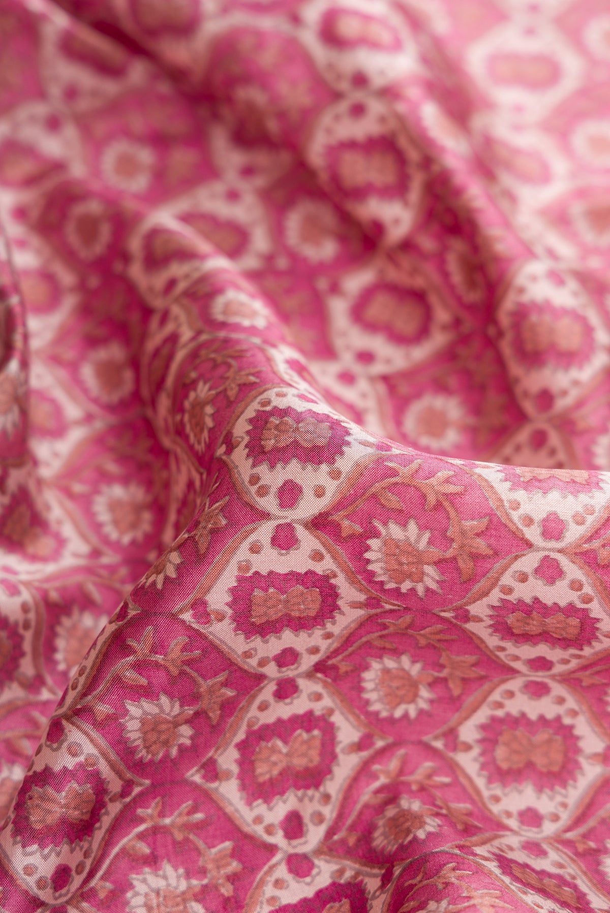 Close up of Dark Pink Dual Tone Kanchipuram Silk Saree with Printed design on the body and Zari And Thread Border.  displaying folds
