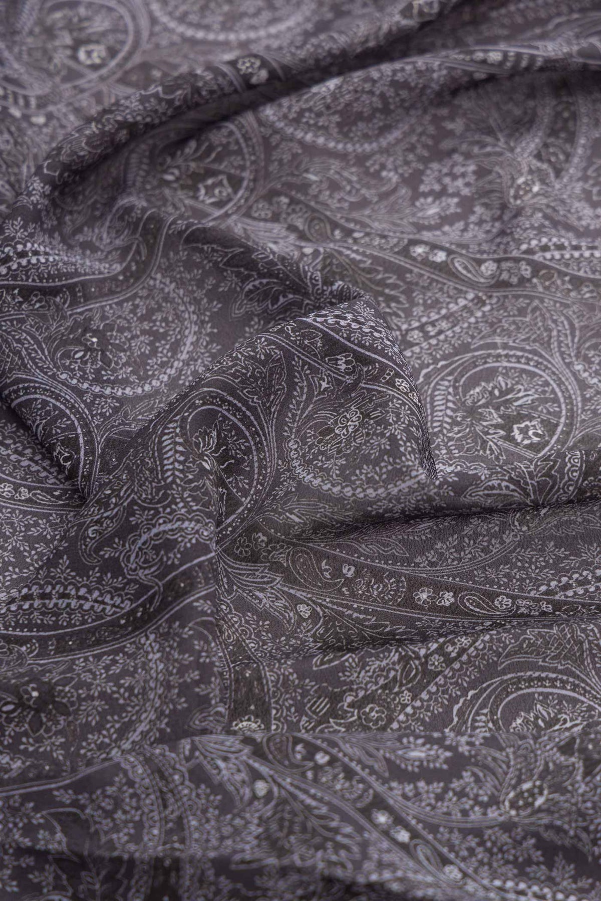 Close up of Grey Dual Tone Mysore Crepe Saree with Printed design on the body and Thread Border displaying folds