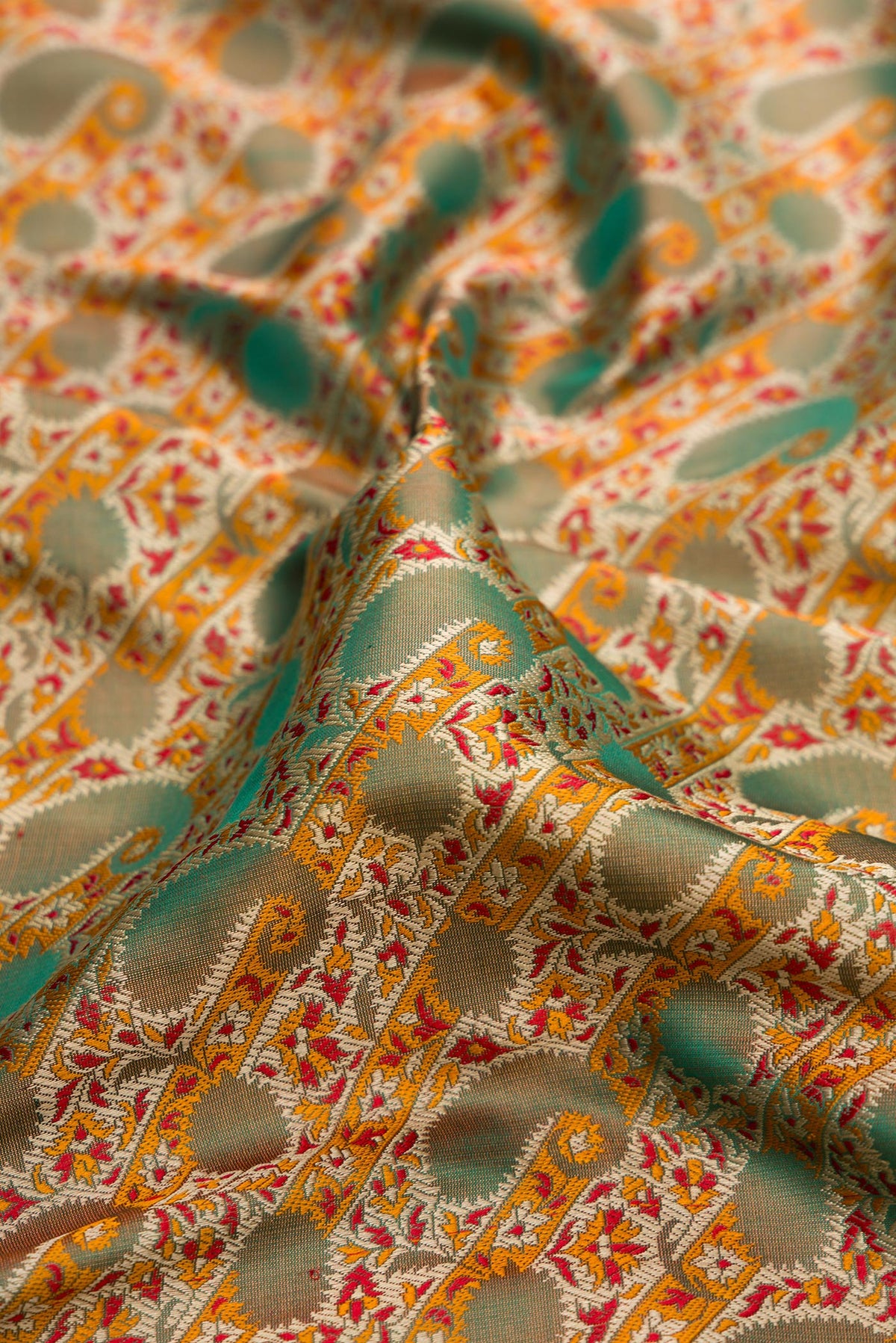 Close up of Green Dual Tone Banarasi Tanchoi Silk Saree with Jacquard design on the body and Fancy Border.  displaying folds