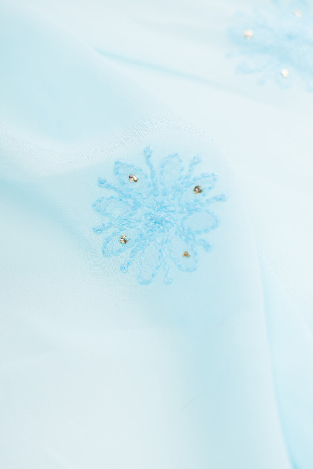 Close up of Sky Blue Dual Tone Georgette Saree with Embroidery on the body and Embroidery Border.  displaying folds