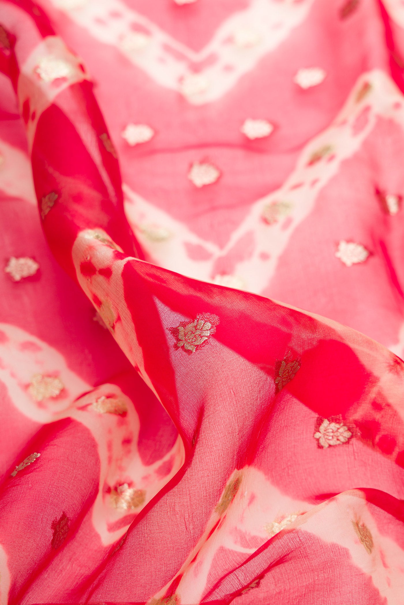 Close up of Red Dual Tone Organza Silk Saree with Zari Butta on the body and Embroidery Border.  displaying folds