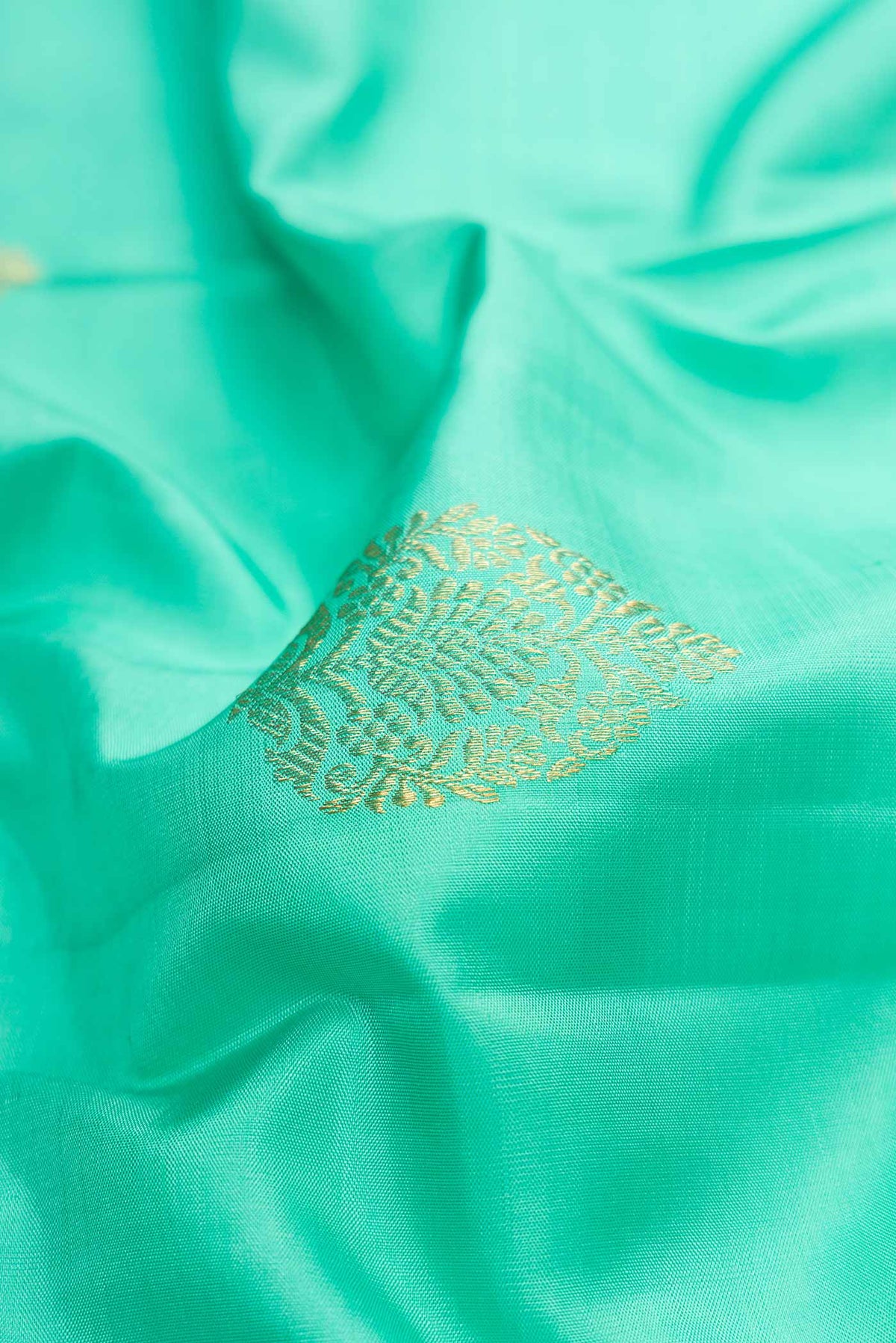 Close up of Sea Green Dual Tone Kanchipuram Silk Saree with Zari Butta on the body and Without Border.  displaying folds