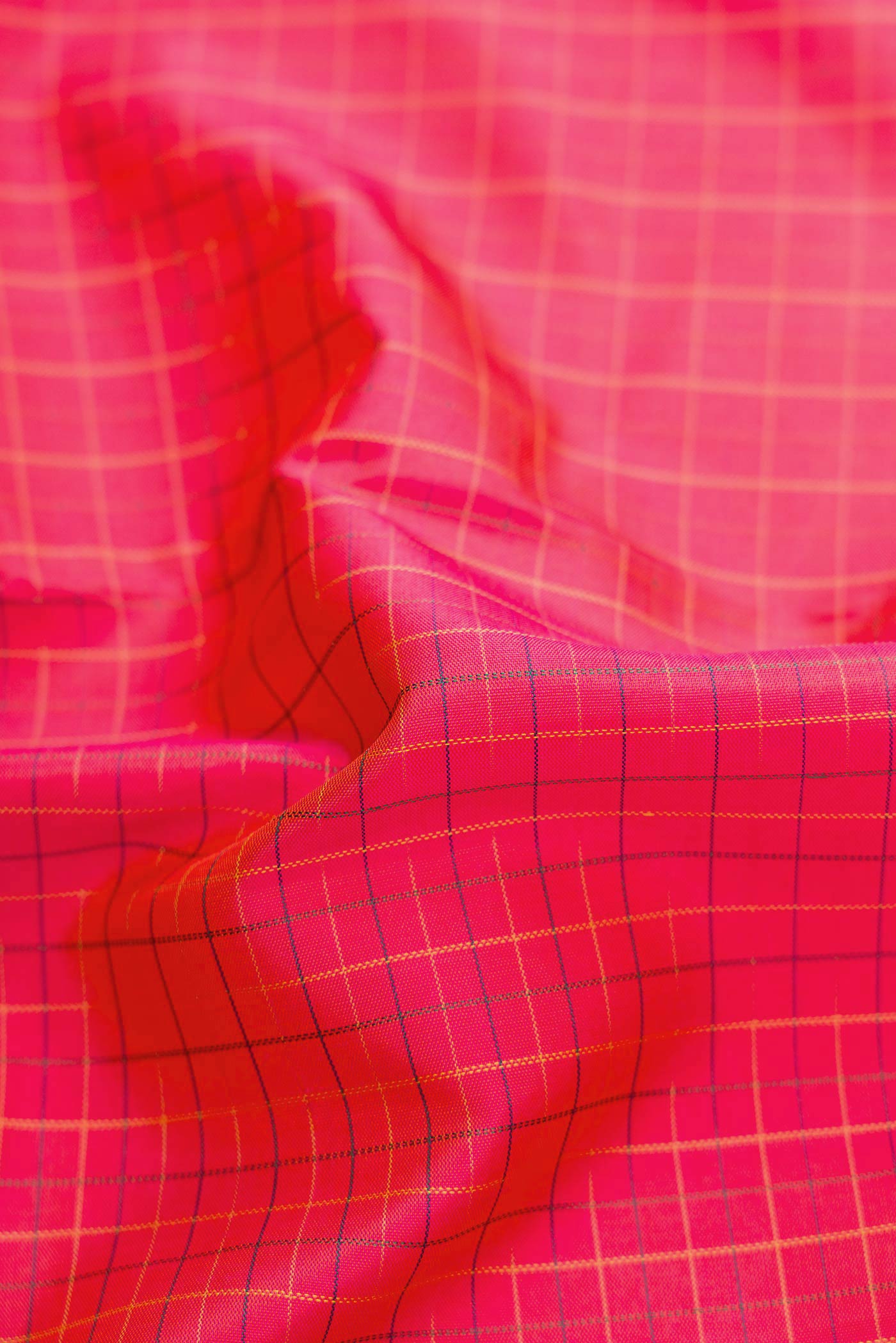 Close up of Coral Dual Tone Kanchipuram Silk Saree with Checked design on the body and Zari Border displaying folds