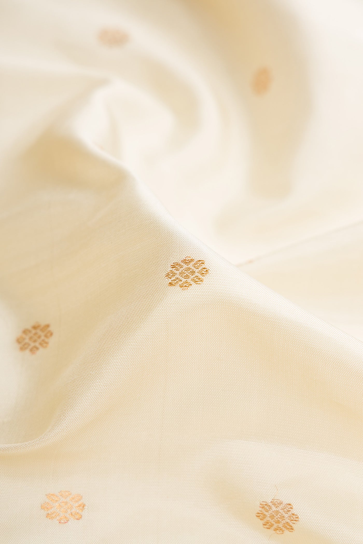 Close up of Off White Dual Tone Gadwal Silk Saree with Zari Butta on the body and Zari Border.  displaying folds