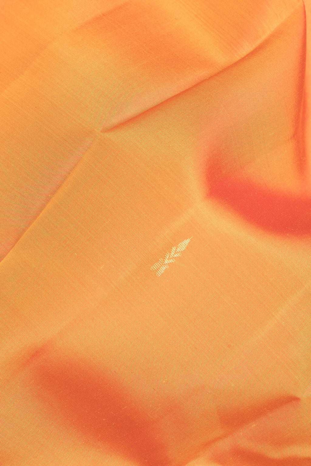 Close up of Pure Silk Orange Kanjivaram Saree with Zari Butta on the body and Fancy Border.  displaying folds
