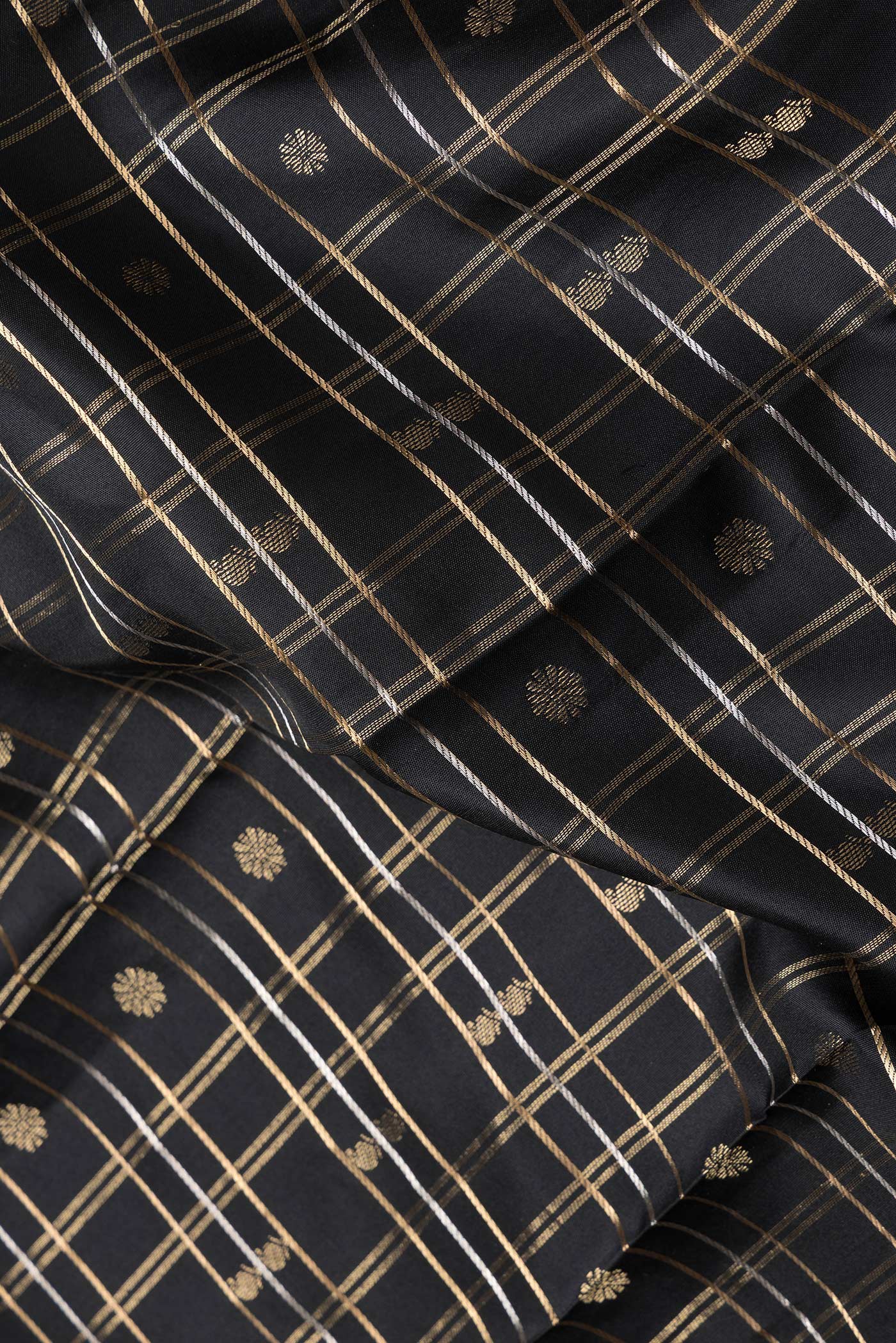 Close up of Black Dual Tone Kanchipuram Silk Saree with Checked design on the body and Zari Border.  displaying folds