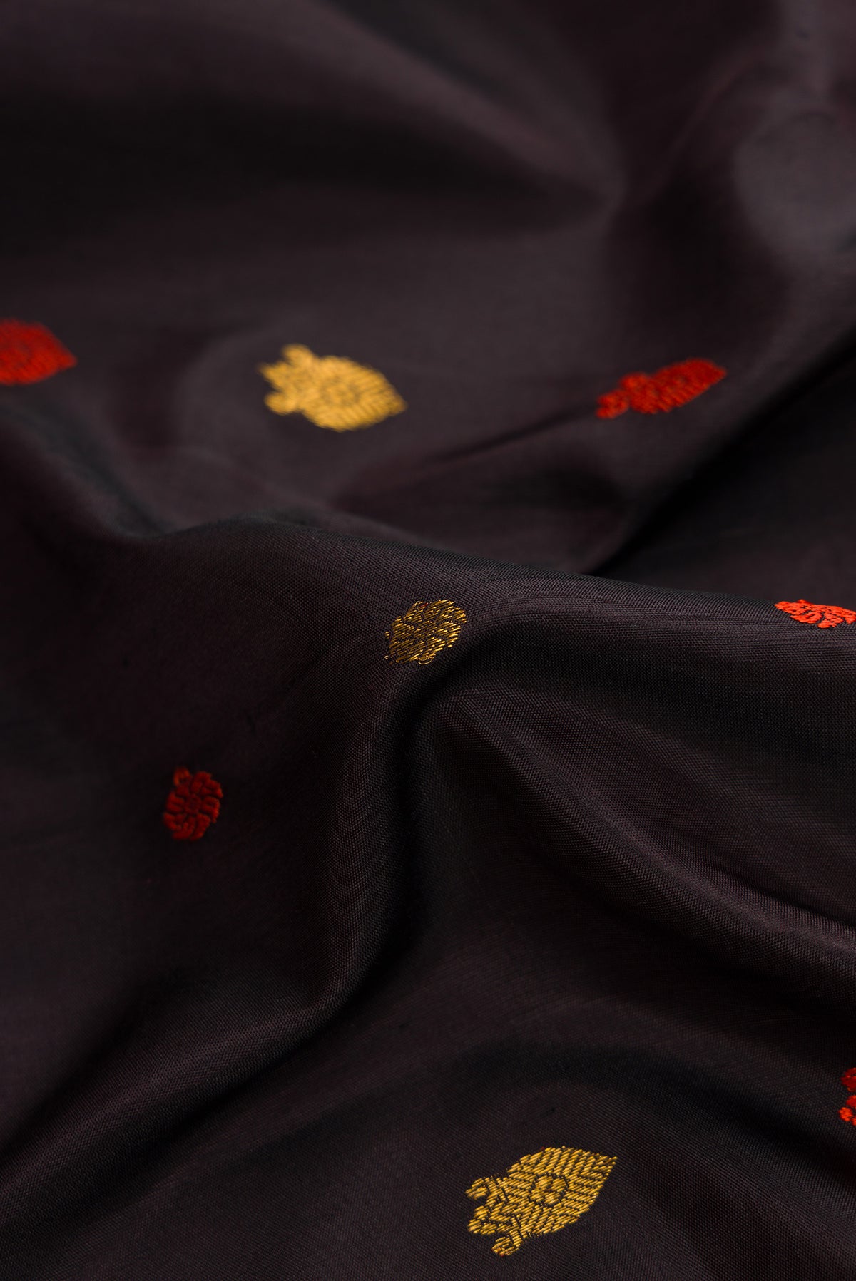 Close up of Black Dual Tone Gadwal Silk Saree with Zari And Thread Butta on the body and Zari Border.  displaying folds