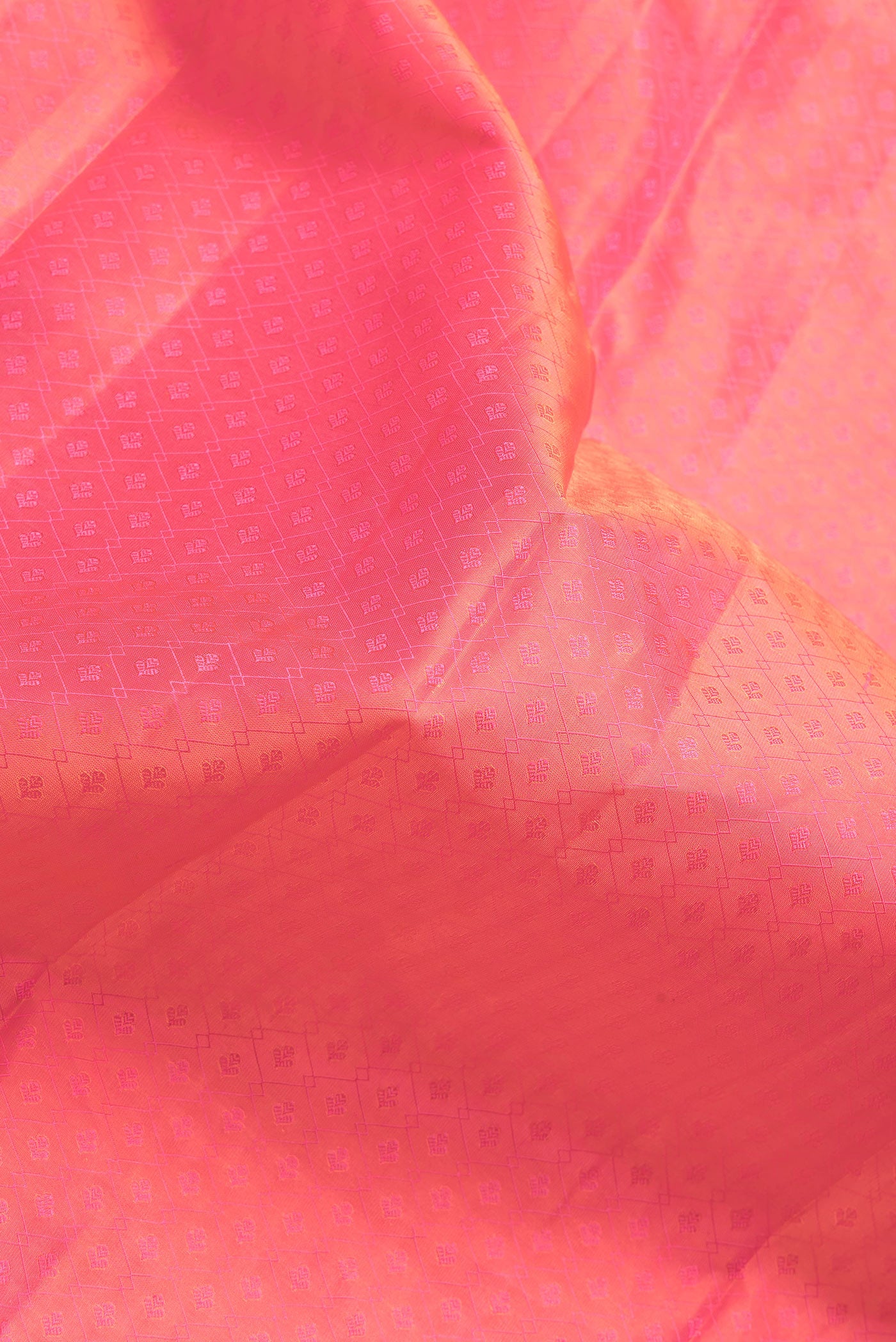 Close up of Coral Dual Tone Kanchipuram Silk Saree with Jacquard design on the body and Zari And Thread Border.  displaying folds