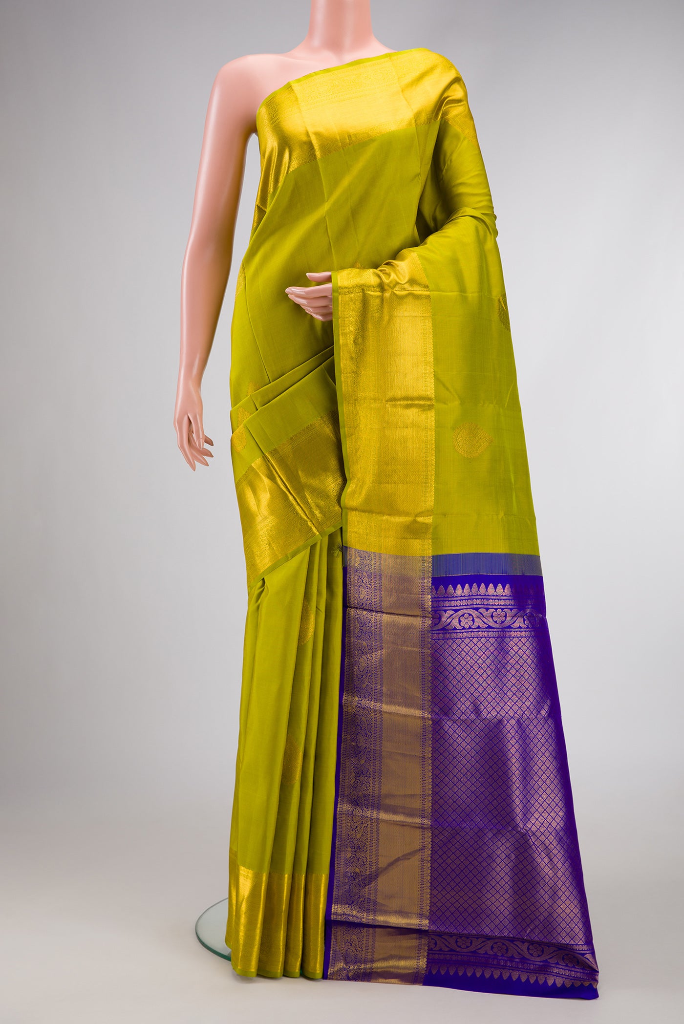 Green Dual Tone Kanjivaram Silk Saree with Zari Butta on the body and Zari Border.  displayed on a mannequin