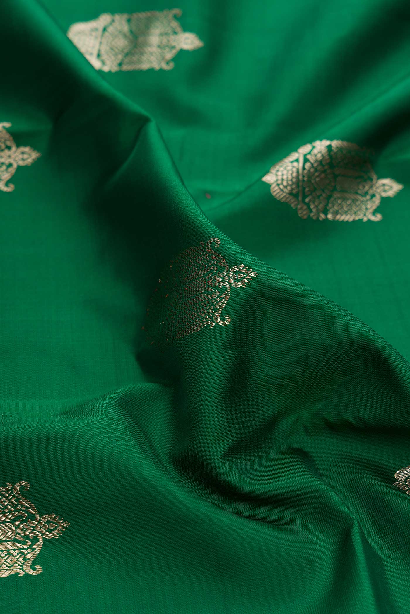 Close up of Green Dual Tone Kanchipuram Silk Saree with Zari Butta on the body and Zari Border displaying folds