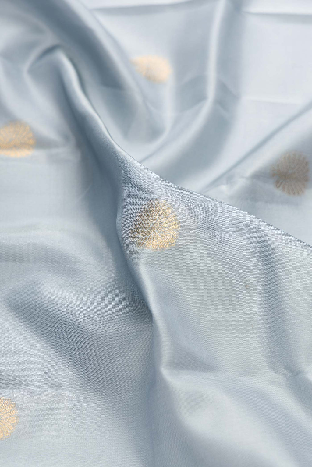 Close up of Grey Dual Tone Kanchipuram Silk Saree with Zari Butta on the body and Zari Border displaying folds