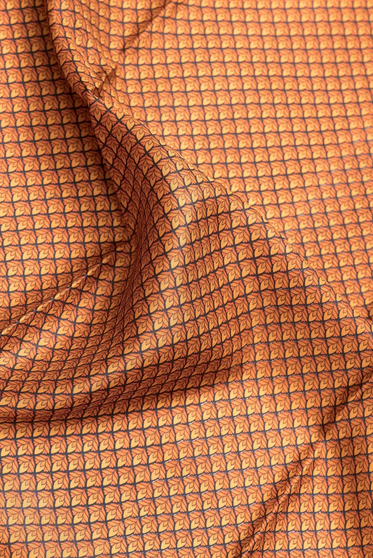 Close up of Orange Dual Tone Printed Silk Saree with Printed design on the body and Printed Border.  displaying folds