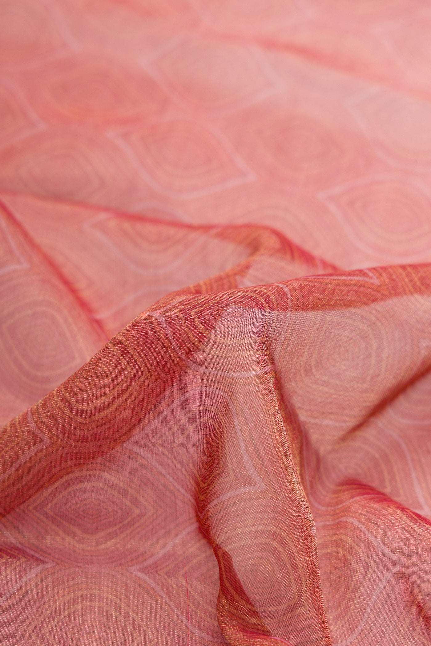 Close up of Golden Peach Dual Tone Mysore Georgette Saree with Zari Brocade on the body and Printed Border.  displaying folds
