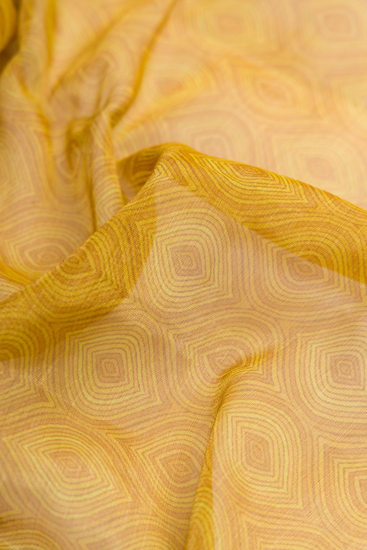 Close up of Mustard Dual Tone Mysore Georgette Saree with Zari Brocade on the body and Printed Border.  displaying folds
