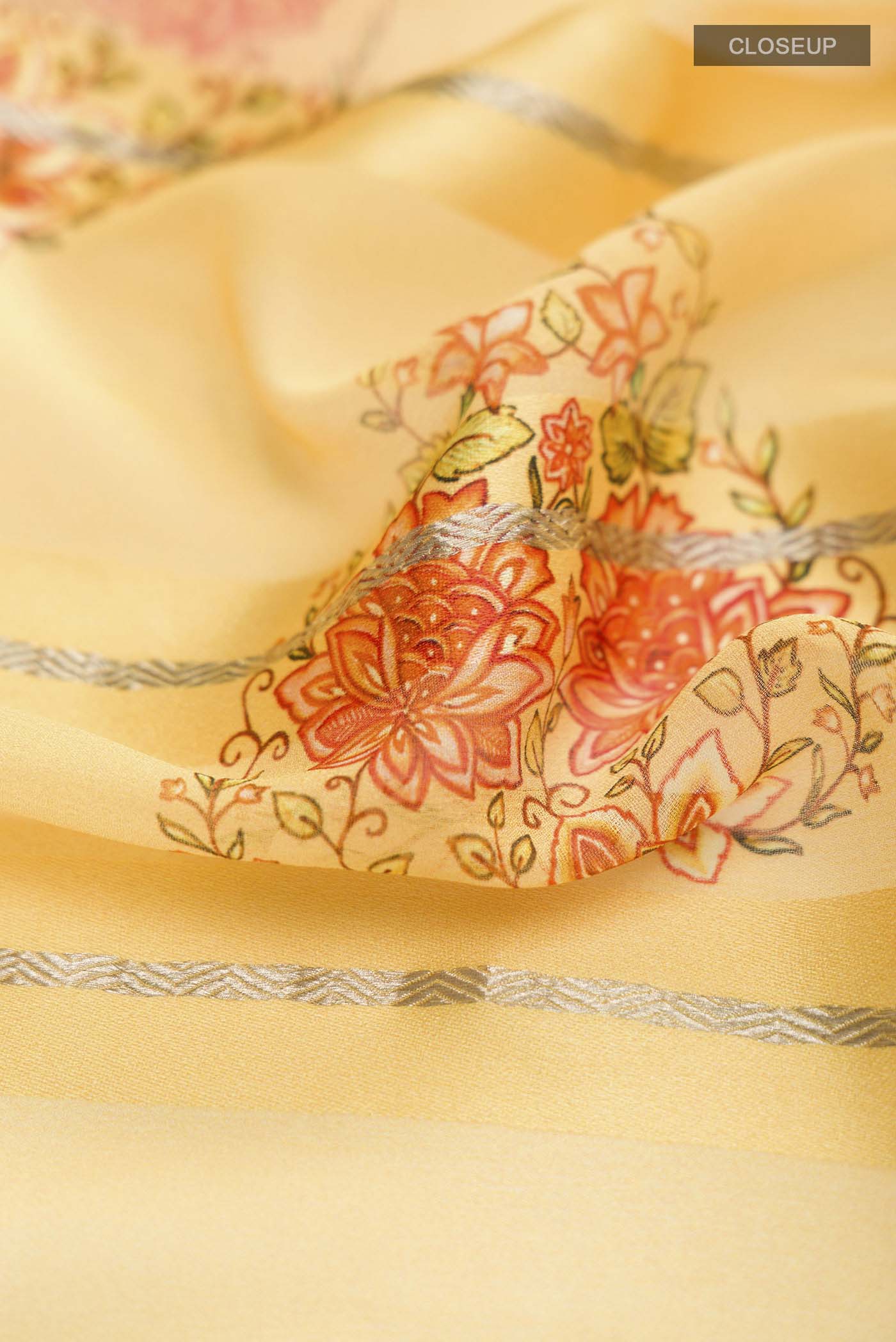 Close up of Yellow Mysore Georgette Saree Printed design on the body and Zari Border displaying folds