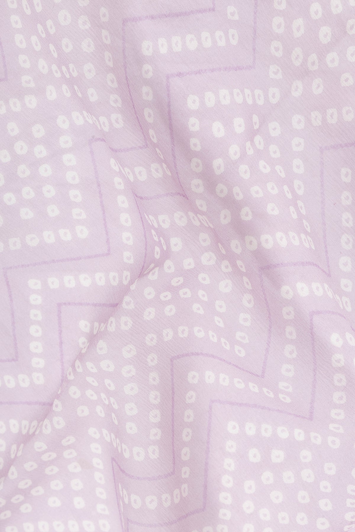 Close up of Lavender Dual Tone Mysore Georgette Saree with Bandhani Print on the body and Zari Border.  displaying folds