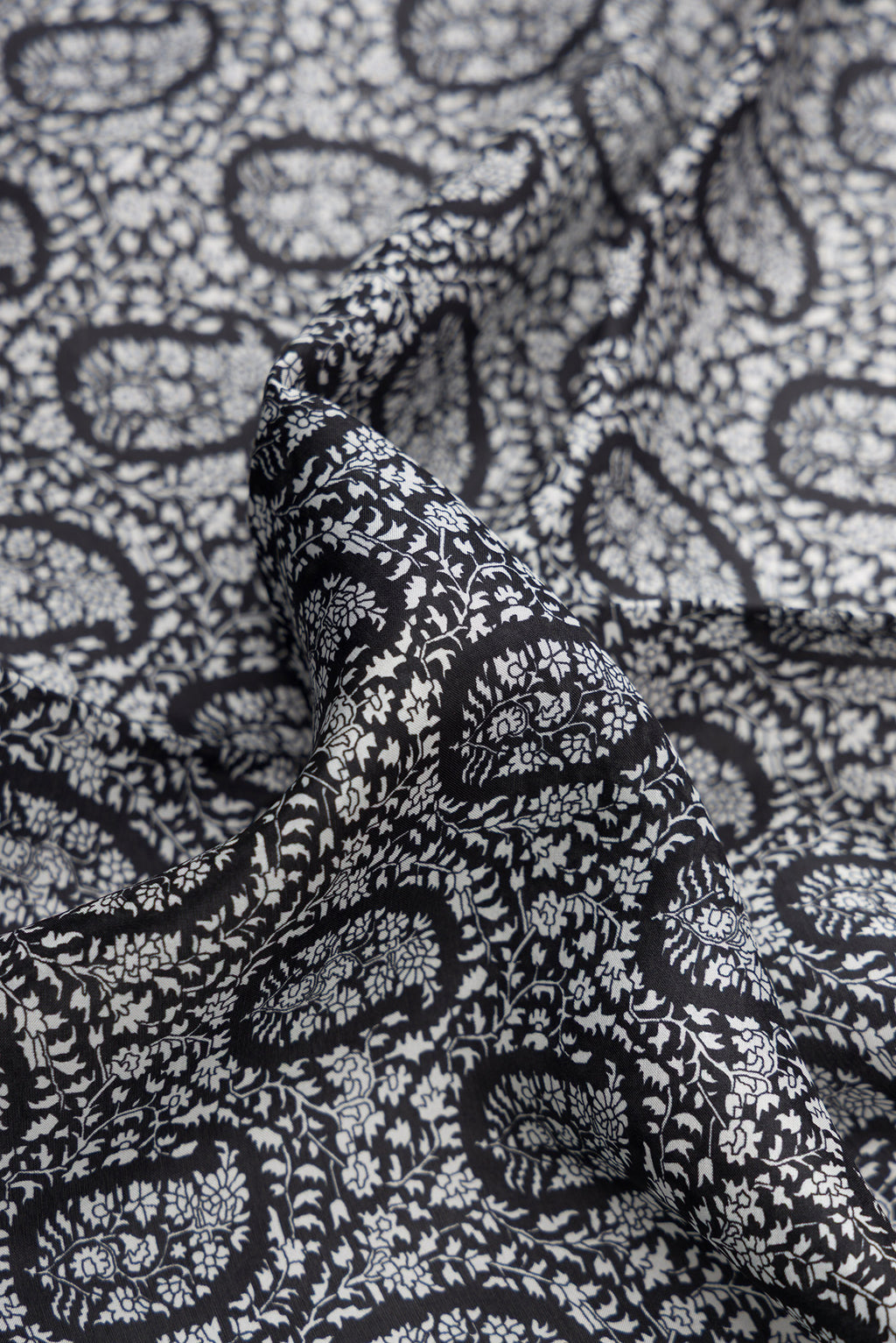 Close up of Black Dual Tone Printed Silk Saree with Printed design on the body and Embroidery Border.  displaying folds