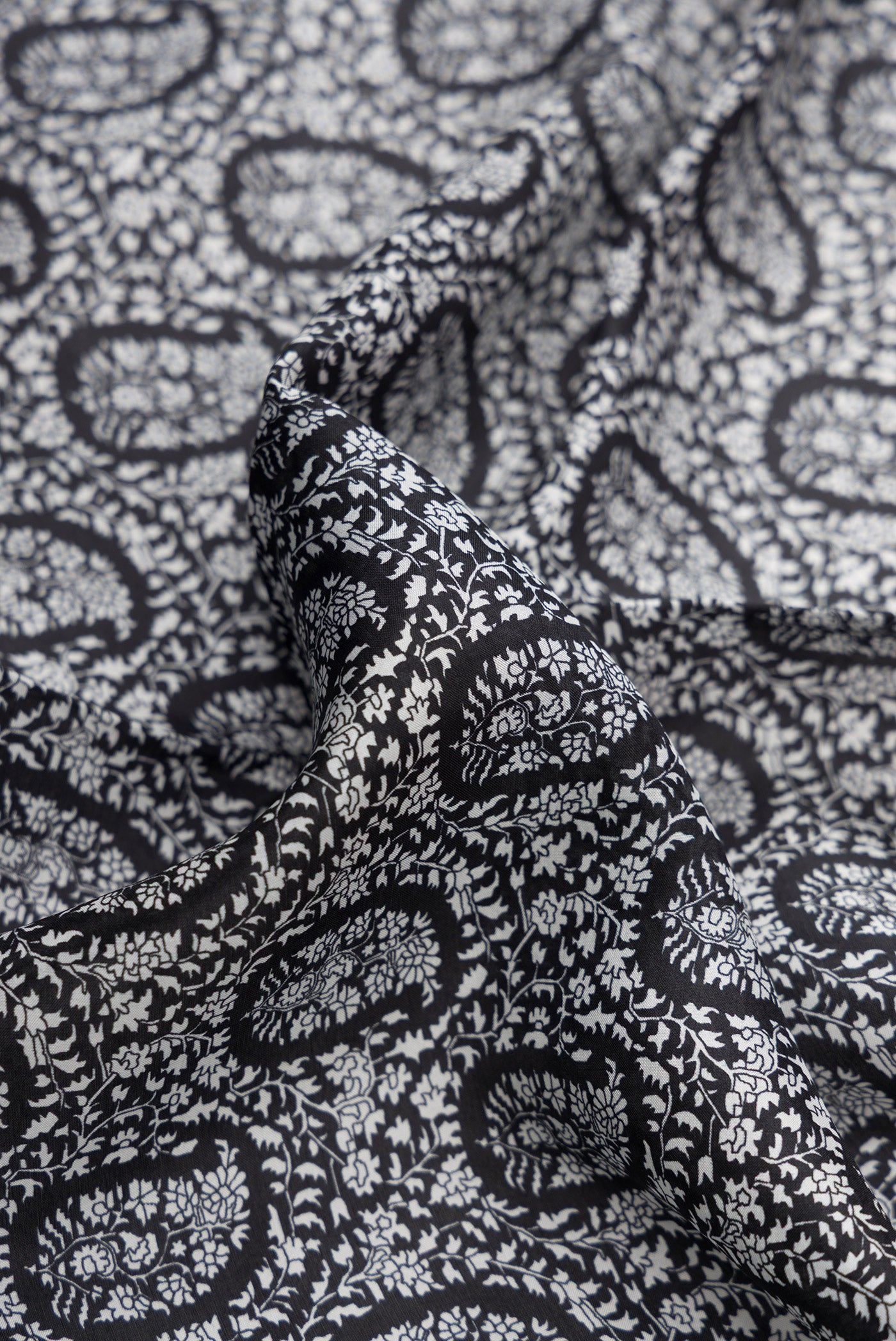 Close up of Black Dual Tone Printed Silk Saree with Printed design on the body and Embroidery Border.  displaying folds
