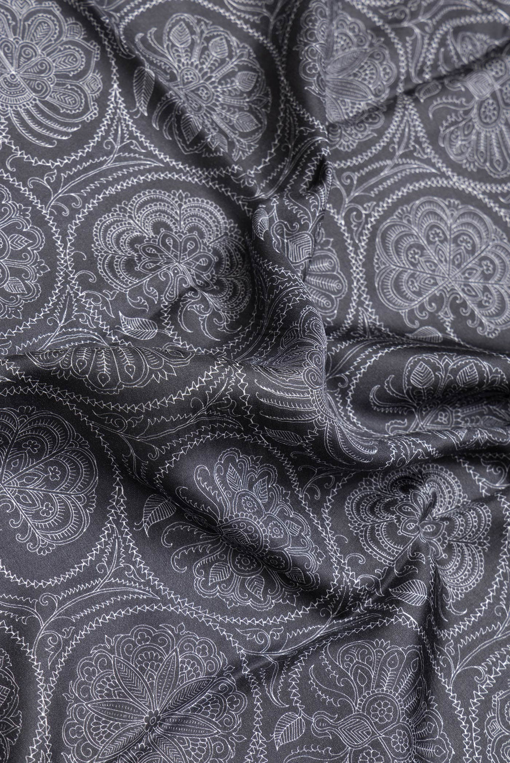 Close up of Black Dual Tone Printed Silk Saree with Printed design on the body and Plain Border.  displaying folds