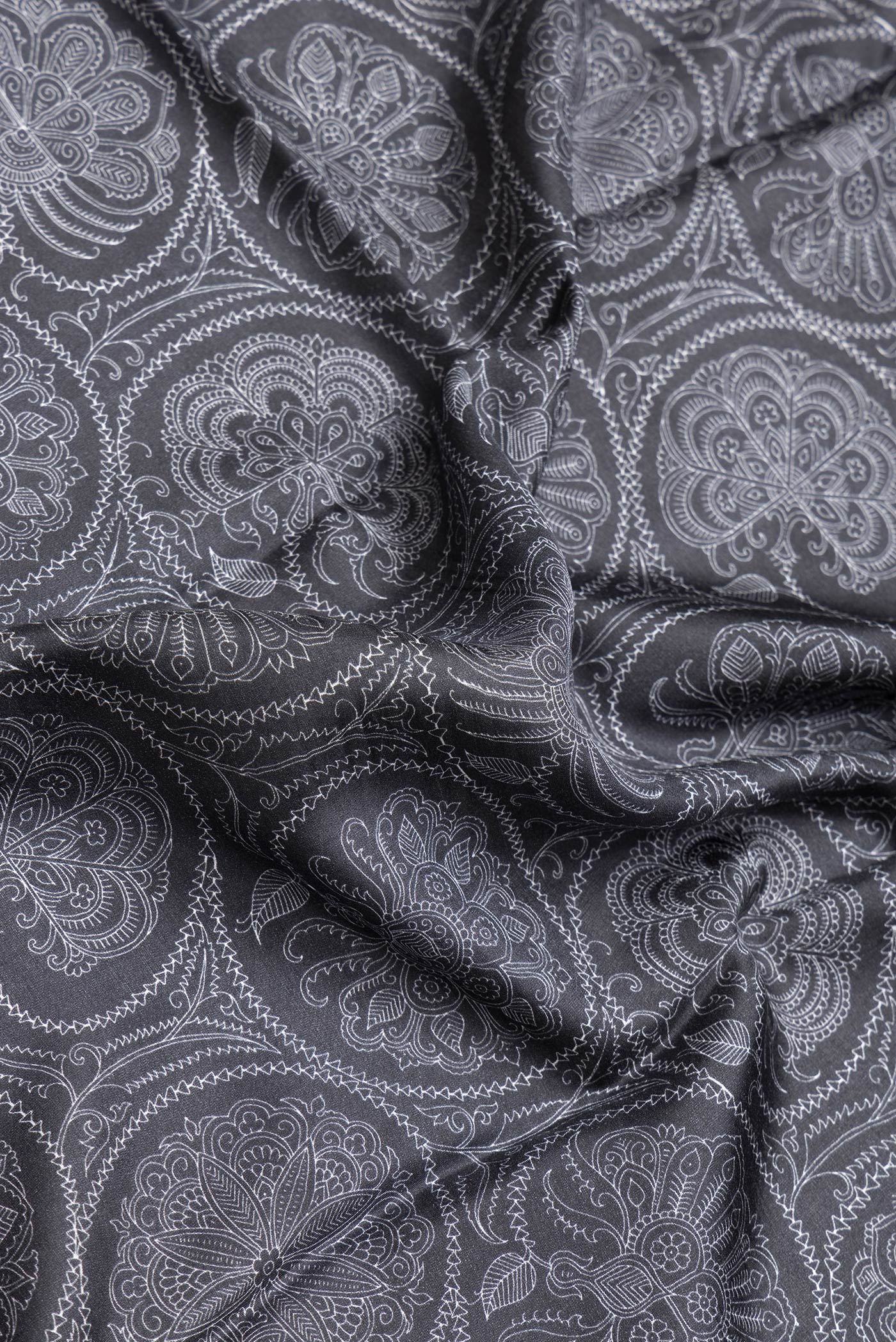 Close up of Black Dual Tone Printed Silk Saree with Printed design on the body and Plain Border.  displaying folds