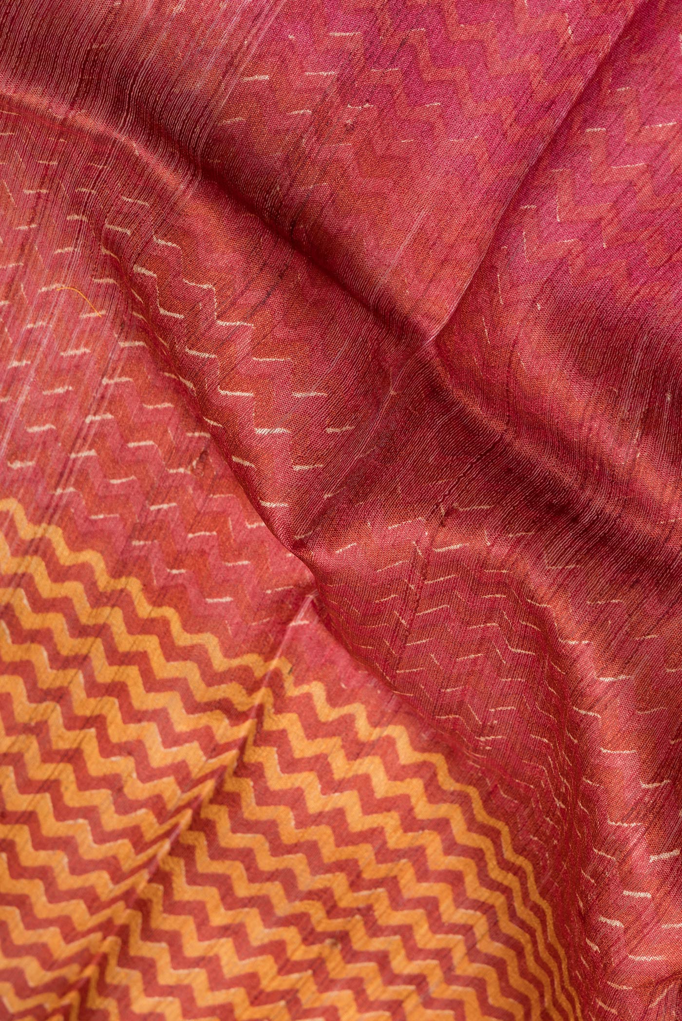 Close up of Multi Color Tussar Silk Saree with Printed design on the body and Embroidery Border.  displaying folds