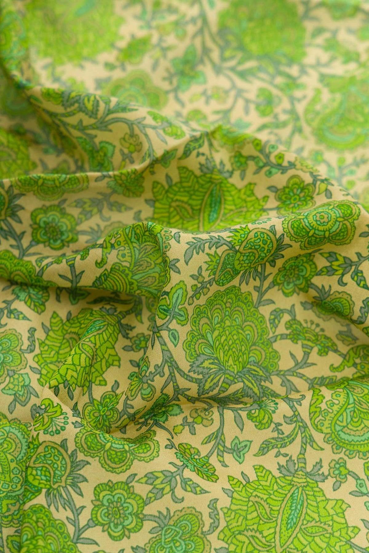 Close up of Green Dual Tone Mysore Crepe Saree with Printed design on the body and Thread Border displaying folds