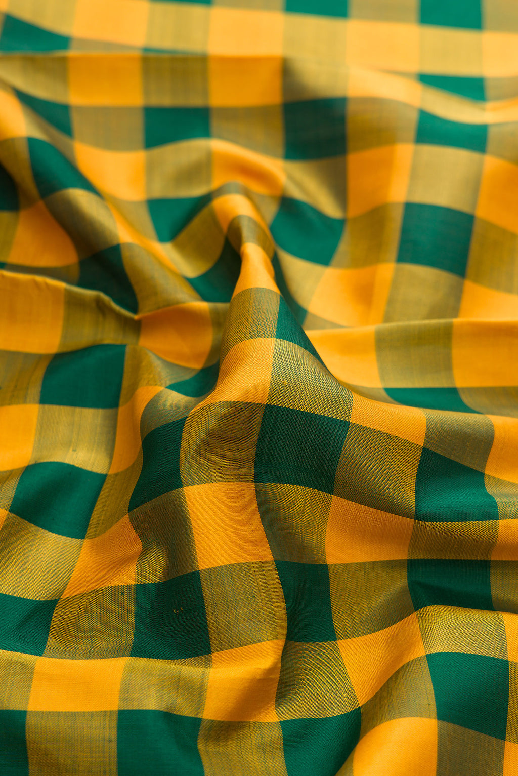 Close up of Pure Silk Pure Zari Green and Mustard Color Kanjivaram Saree with Checked design on the body and Zari Border.  displaying folds