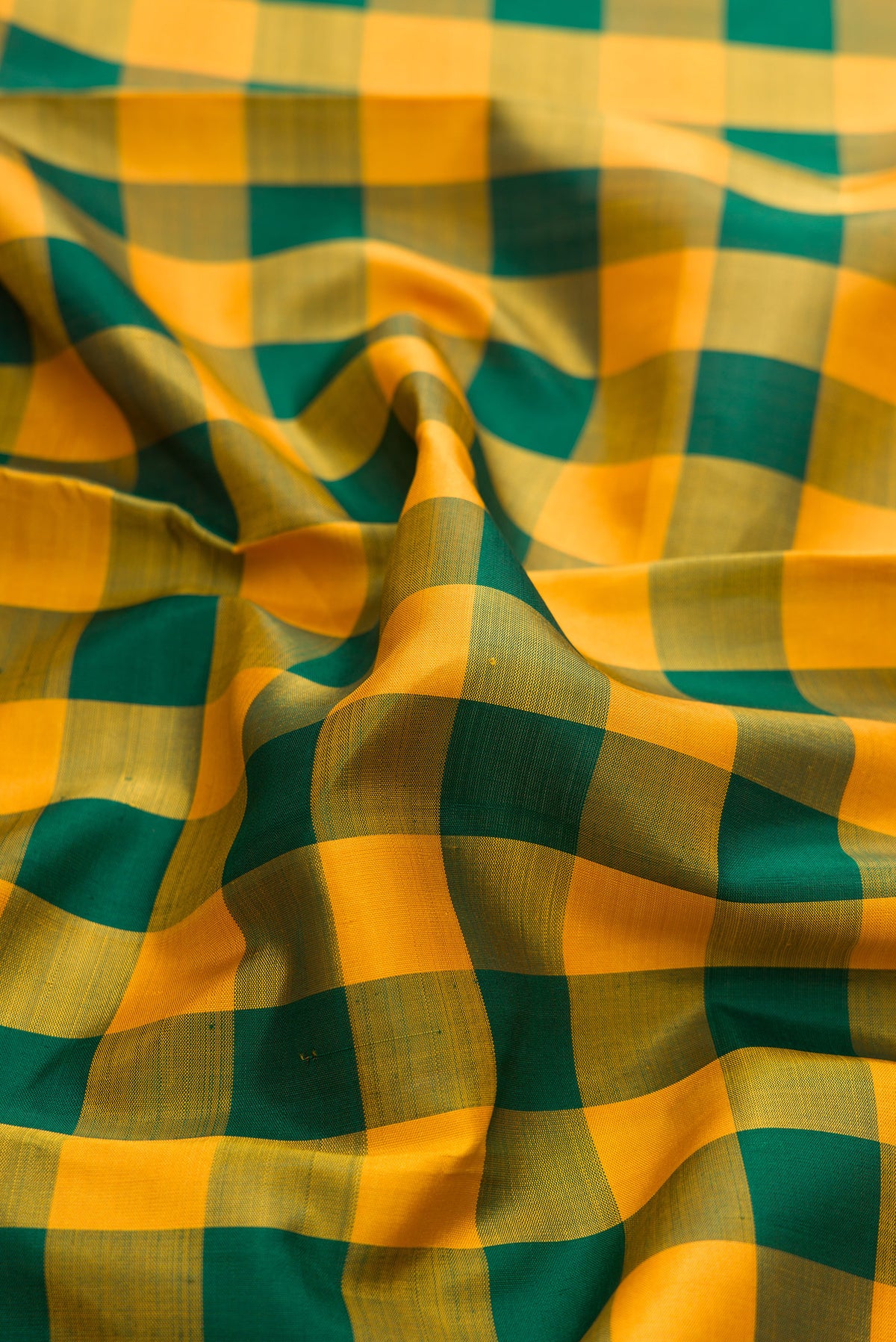 Close up of Pure Silk Pure Zari Green and Mustard Color Kanjivaram Saree with Checked design on the body and Zari Border.  displaying folds