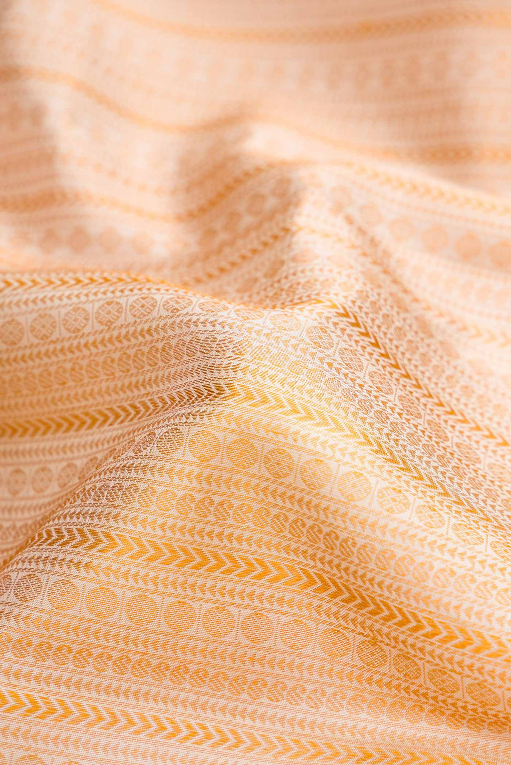 Close up of Beige Dual Tone Kanchipuram Silk Saree with Zari Butta on the body and Zari Border.  displaying folds