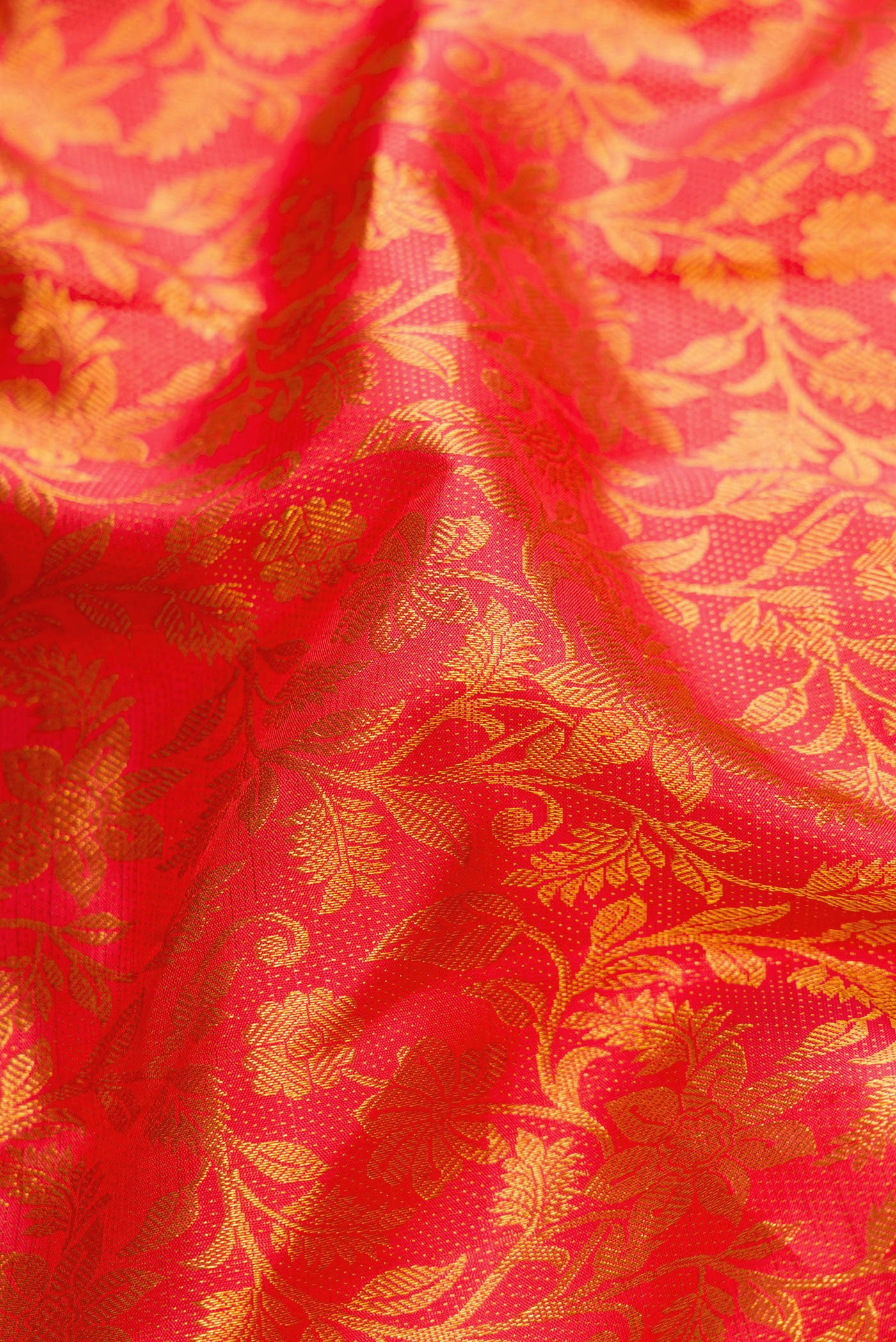 Close up of Coral Dual Tone Kanjivaram Silk Saree with Zari Brocade on the body and Zari Border.  displaying folds