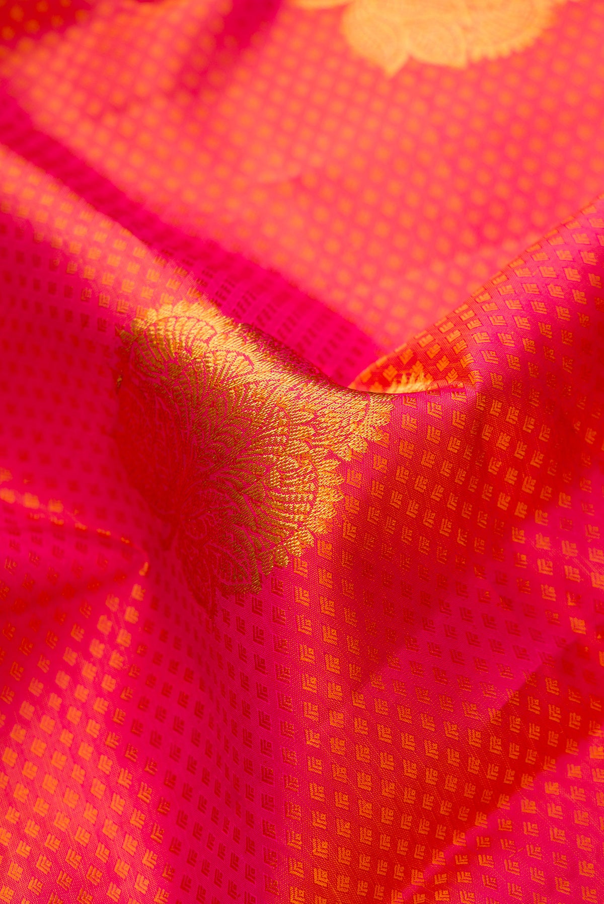 Close up of Dark Pink Dual Tone Kanchipuram Silk Saree with Jacquard With Zari Butta on the body and Zari Border.  displaying folds