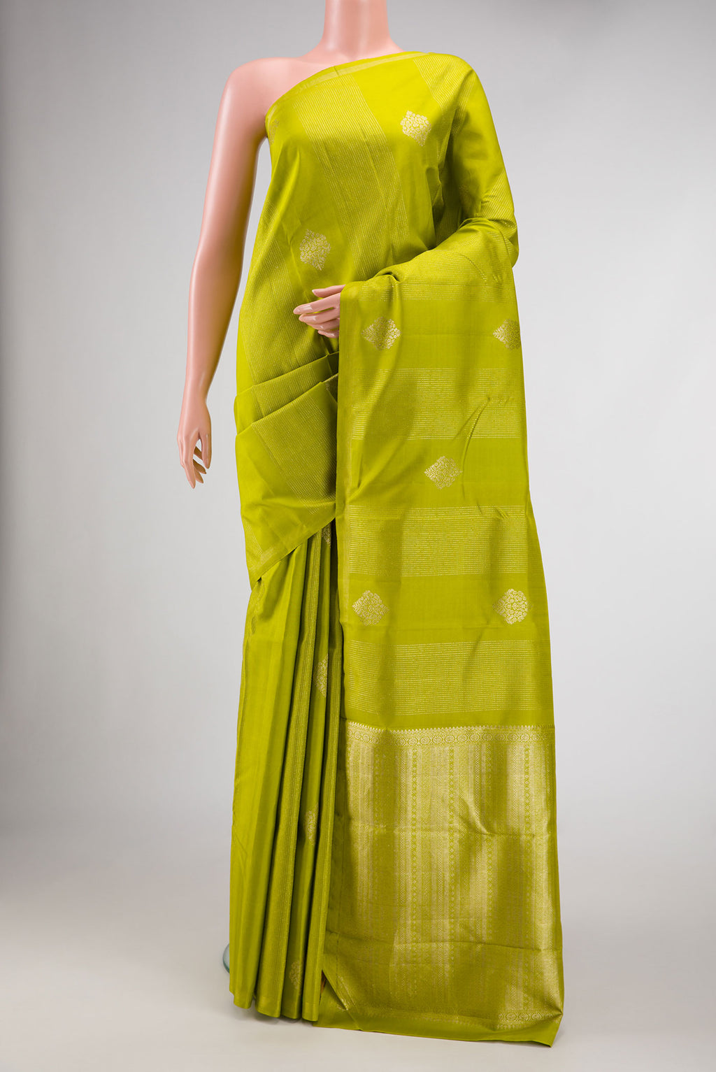 Parrot Green Dual Tone Kanchipuram Silk Saree with Stripes on the body and Zari Border.  displayed on a mannequin
