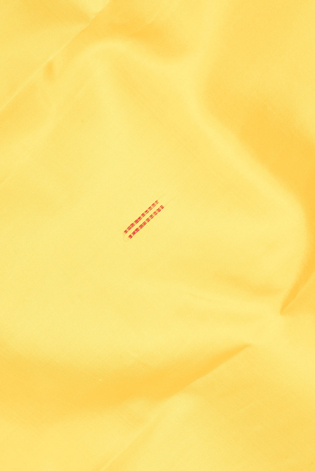 Close up of Pure Silk Yellow Kanchipuram Saree with Thread Butta on the body and Thread Border.  displaying folds