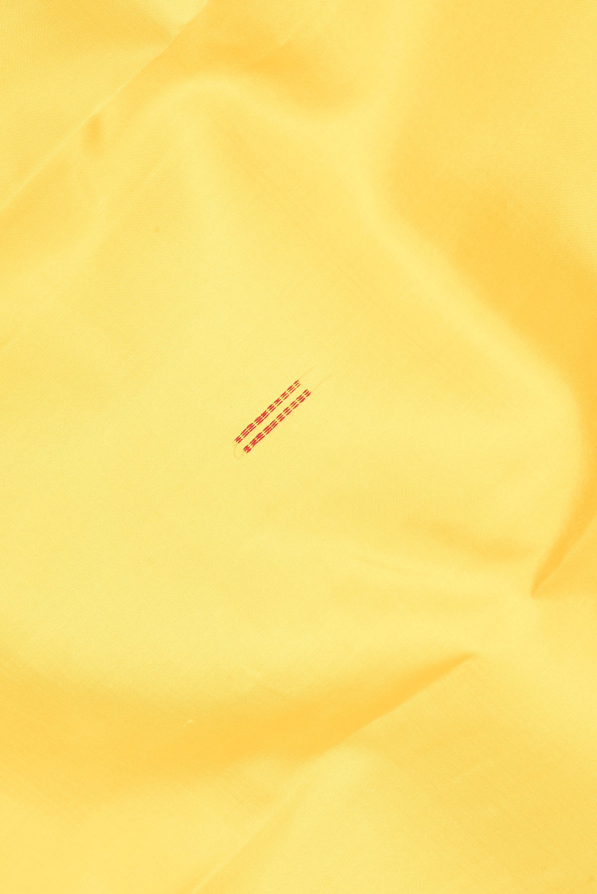 Close up of Pure Silk Yellow Kanchipuram Saree with Thread Butta on the body and Thread Border.  displaying folds