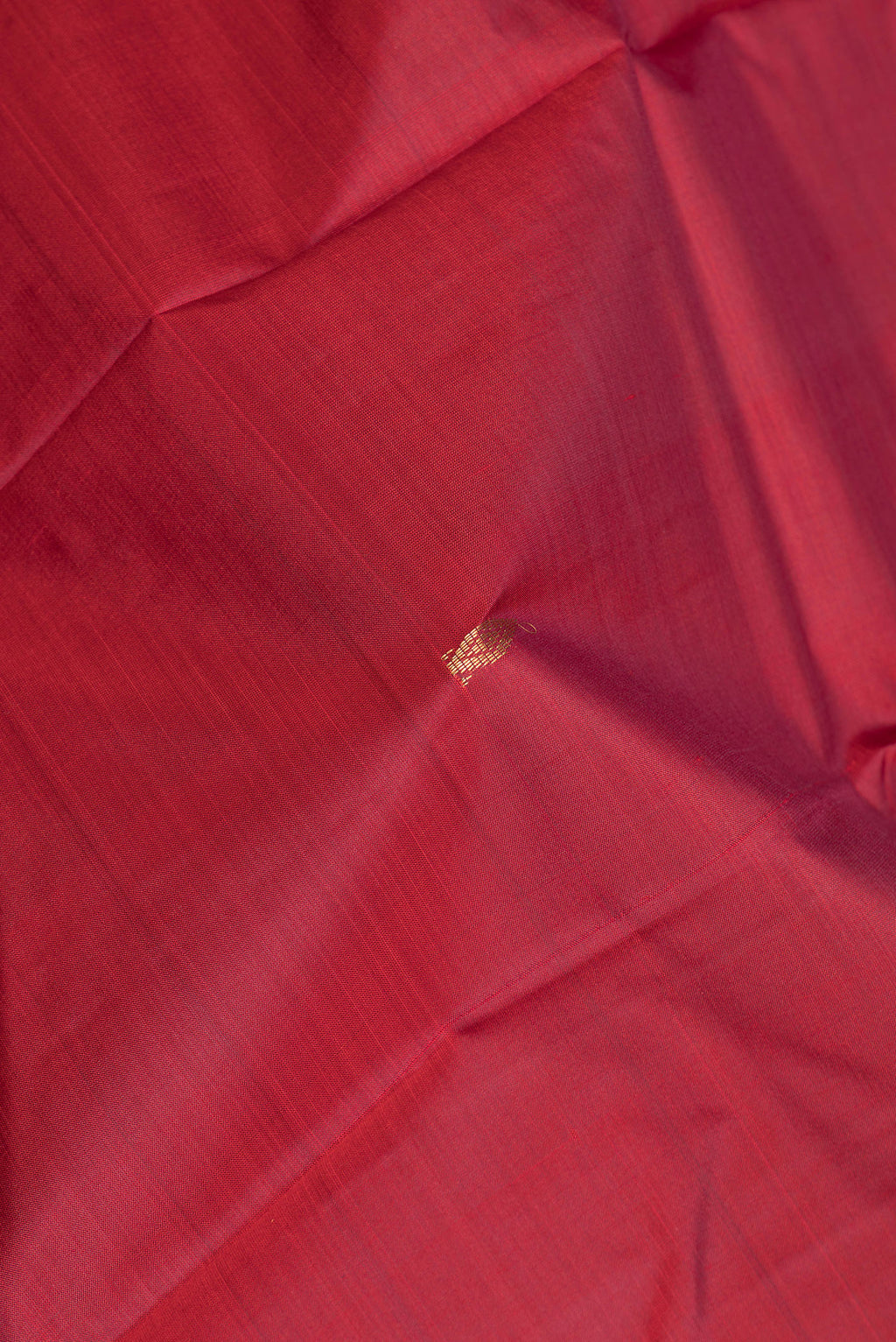Close up of Pure Silk Deep Red Kanjivaram Saree with Zari Butta on the body and Fancy Border.  displaying folds