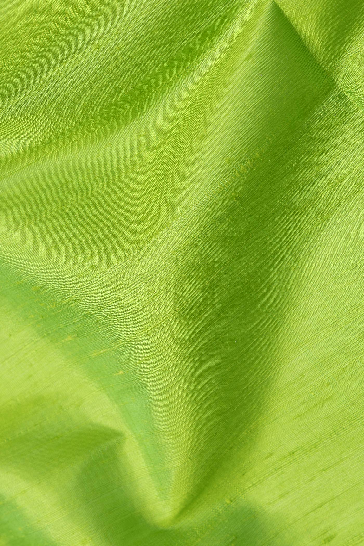 Close up of Parrot Green Dual Tone Raw Silk Saree with Plain Body and Zari Border.  displaying folds