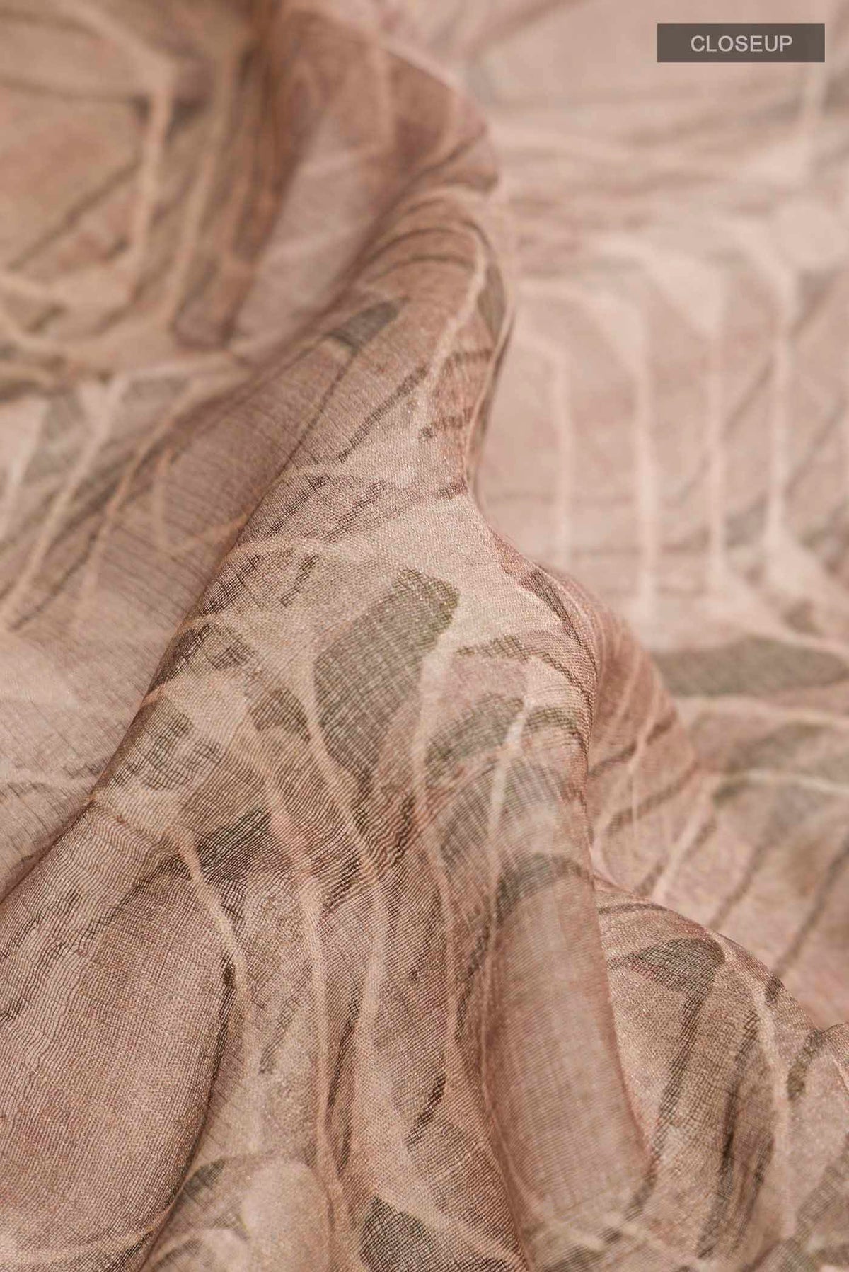 Close up of Dark Beige Tussar Silk Saree with Printed design on the body and Zari Border displaying folds