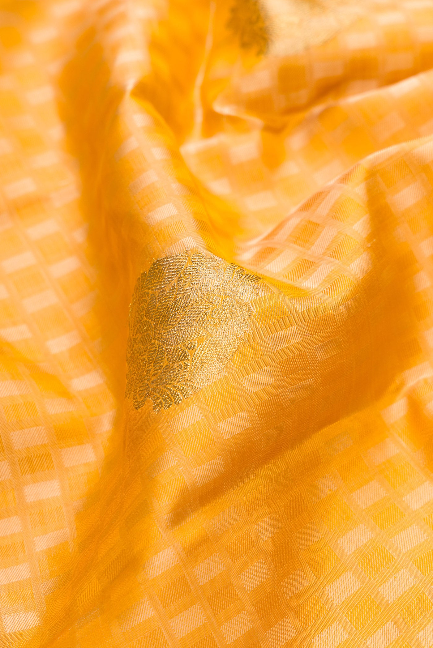 Close up of Pure Silk Pure Zari Gold Dual Tone Kanjivaram Saree with Jacquard With Zari Butta on the body and Zari Border.  displaying folds