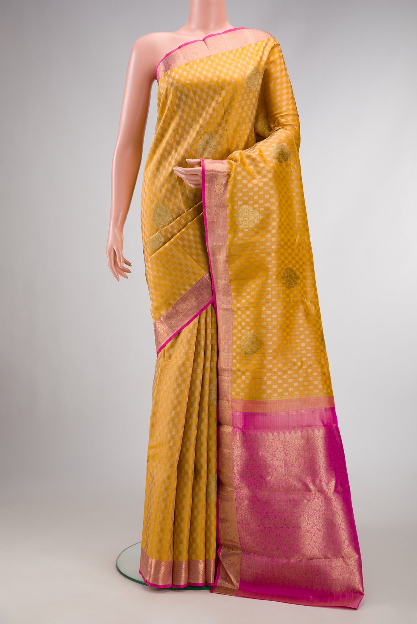 Pure Silk Pure Zari Gold Dual Tone Kanjivaram Saree with Jacquard With Zari Butta on the body and Zari Border.  displayed on a mannequin