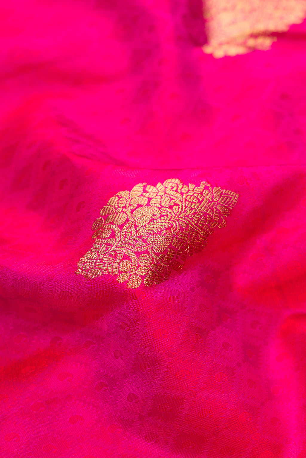 Close up of Pure Silk Pure Zari Magenta Dual Tone Kanchipuram Saree with Jacquard With Zari Butta on the body and Zari Border.  displaying folds