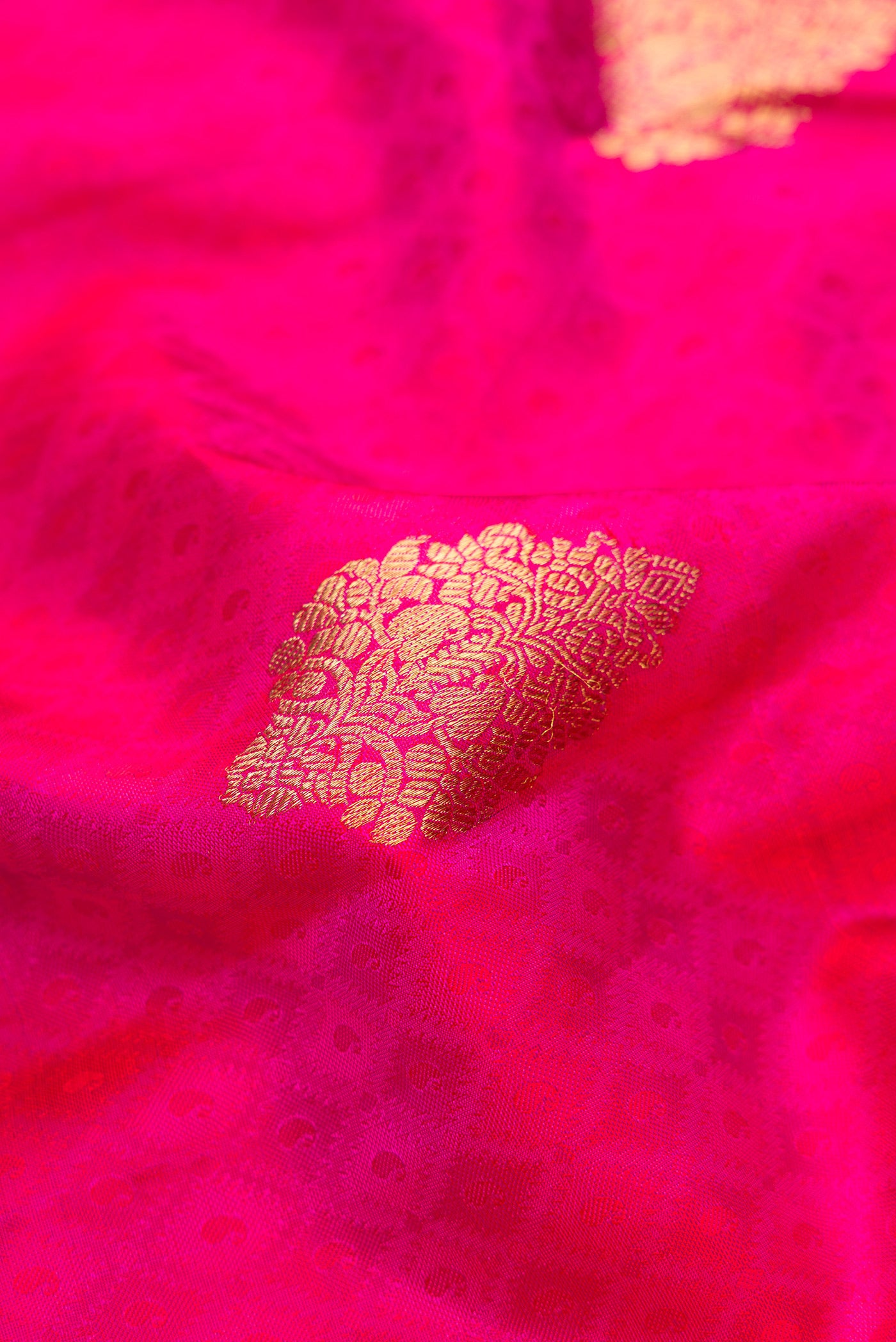 Close up of Pure Silk Pure Zari Magenta Dual Tone Kanchipuram Saree with Jacquard With Zari Butta on the body and Zari Border.  displaying folds