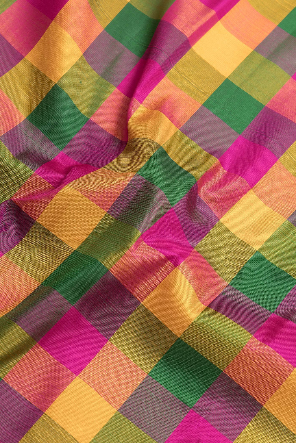 Close up of Mustard, Green and Pink Color Kanchipuram Silk Saree with Checked design on the body and Thread Border.  displaying folds