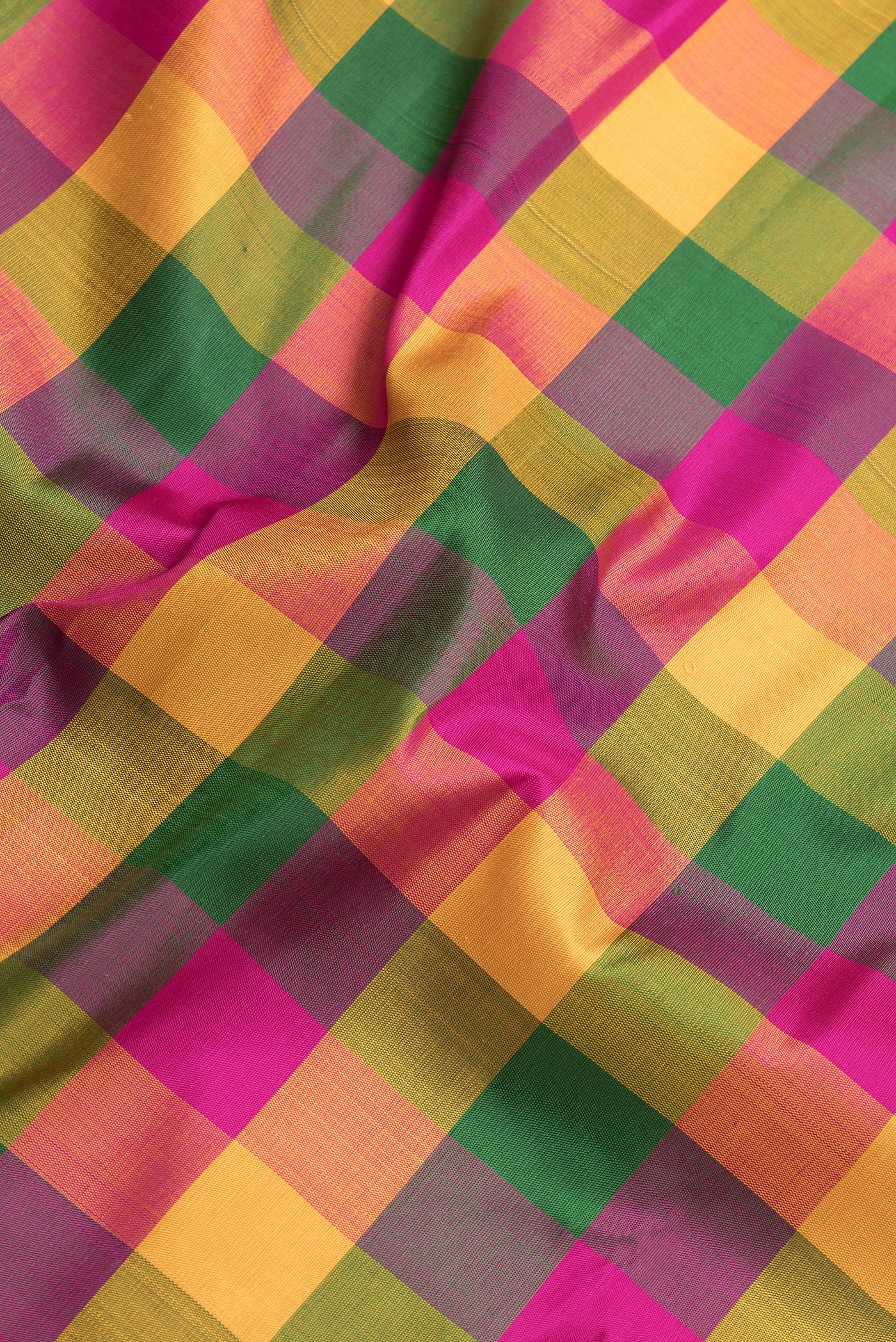 Close up of Mustard, Green and Pink Color Kanchipuram Silk Saree with Checked design on the body and Thread Border.  displaying folds